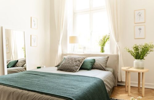 Eco cotton linen and blanket on a bed in nature loving family guesthouse for spring and summer vacation. Real photo.