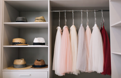 modern-bright-dressing-room-with-shelves-fashionable-hats-beautiful-pink-red-dresses-hanging-wardrobe